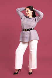 Mujer sonríe usando la blusa Aurora en color gris. 