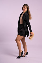 Mujer sonríe usando el blazer Inspiración en color negro. 