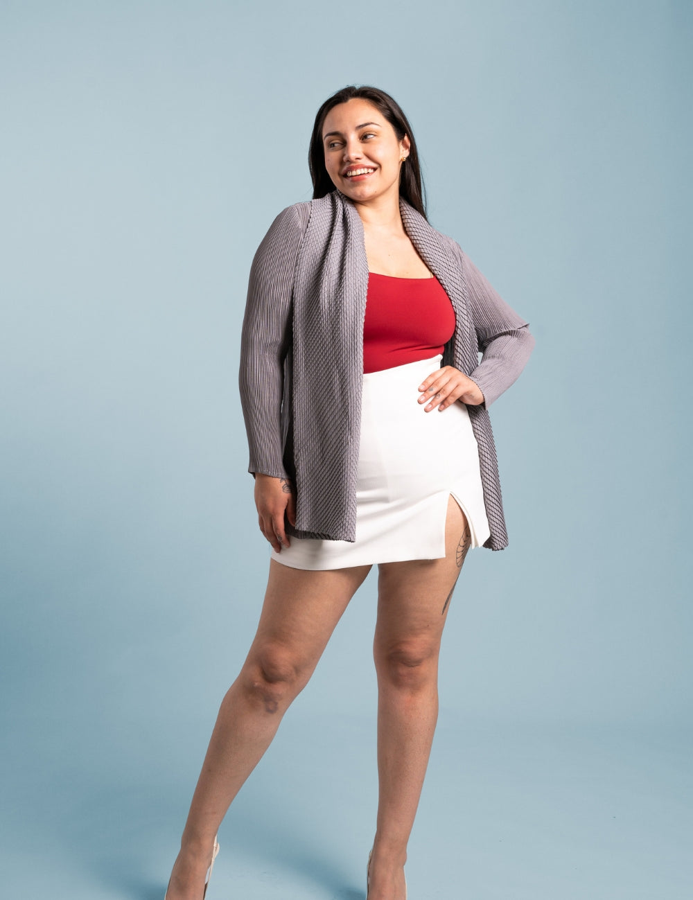 Mujer sonríe usando el blazer Inspiración en color gris. 
