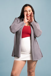 Mujer sonríe usando el blazer Inspiración en color gris. 