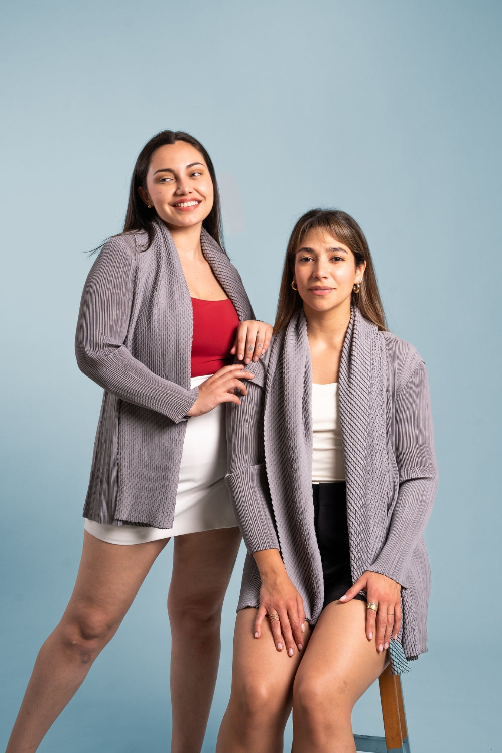 Dos mujeres posan usando el blazer Inspiración en color gris. 