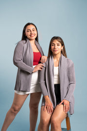 Dos mujeres posan usando el blazer Inspiración en color gris. 