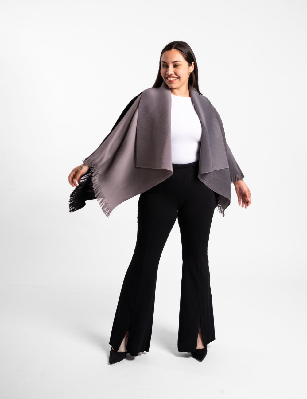 Una mujer usando la capa Visionaria en color negro y gris. 