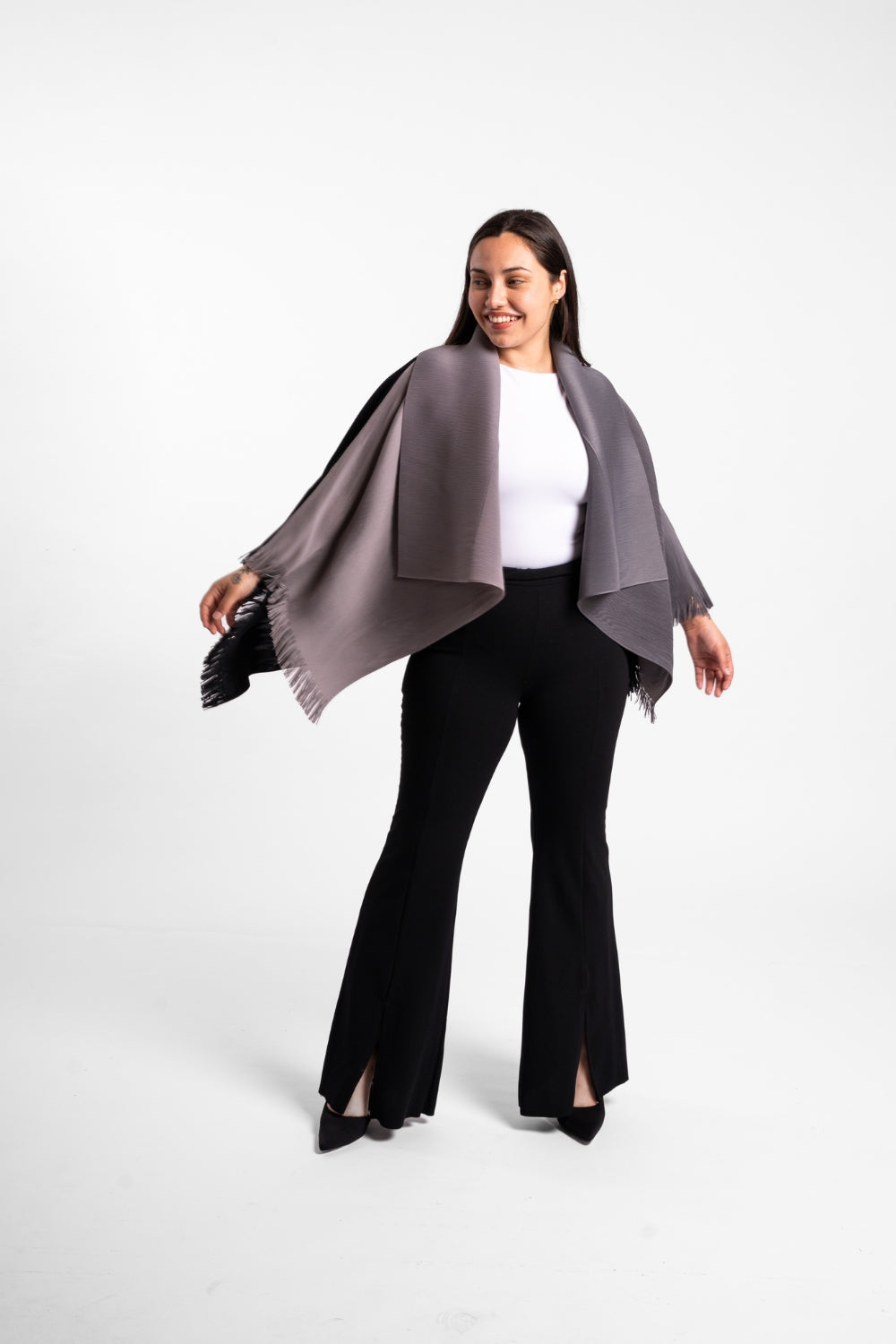 Una mujer usando la capa Visionaria en color negro y gris. 