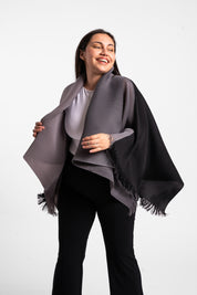 Una mujer usando la capa Visionaria en color negro y gris. 