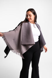 Una mujer usando la capa Visionaria en color negro y gris. 