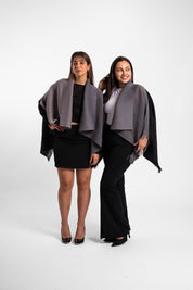 Dos mujeres usando la capa Visionaria en color negro y gris. 