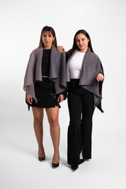 Dos mujeres usando la capa Visionaria en color negro y gris. 