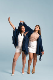 Dos mujeres usando la capa Visionaria en color azul. 