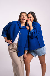 Dos mujeres usando la casaca Confianza en color azul.