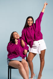 Dos mujeres usando la casaca Auténtica en color rosado.
