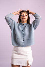 Una mujer usando la chaqueta Esperanza en color celeste.